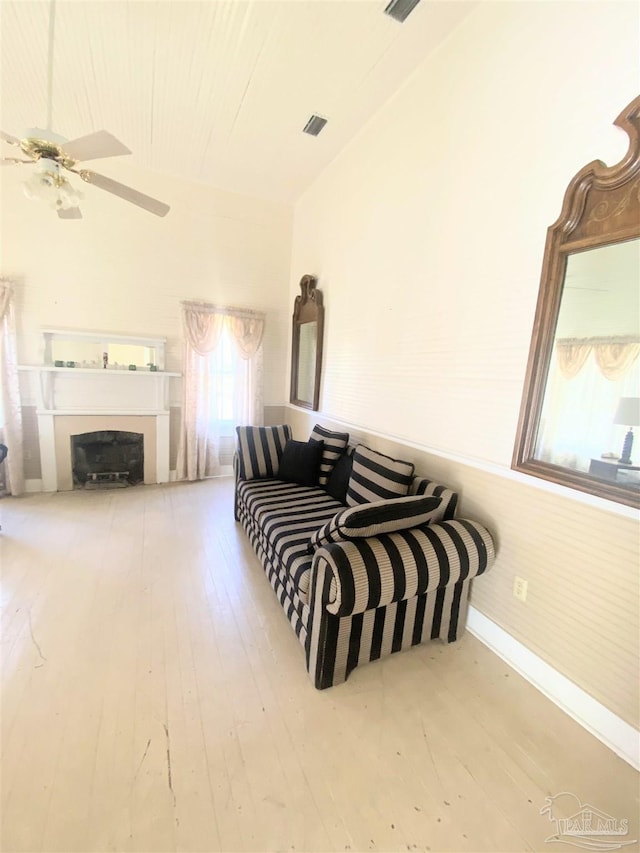 living area featuring wood-type flooring and ceiling fan