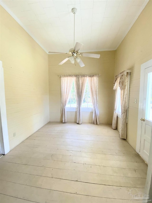 unfurnished room featuring crown molding, ceiling fan, and light wood-type flooring