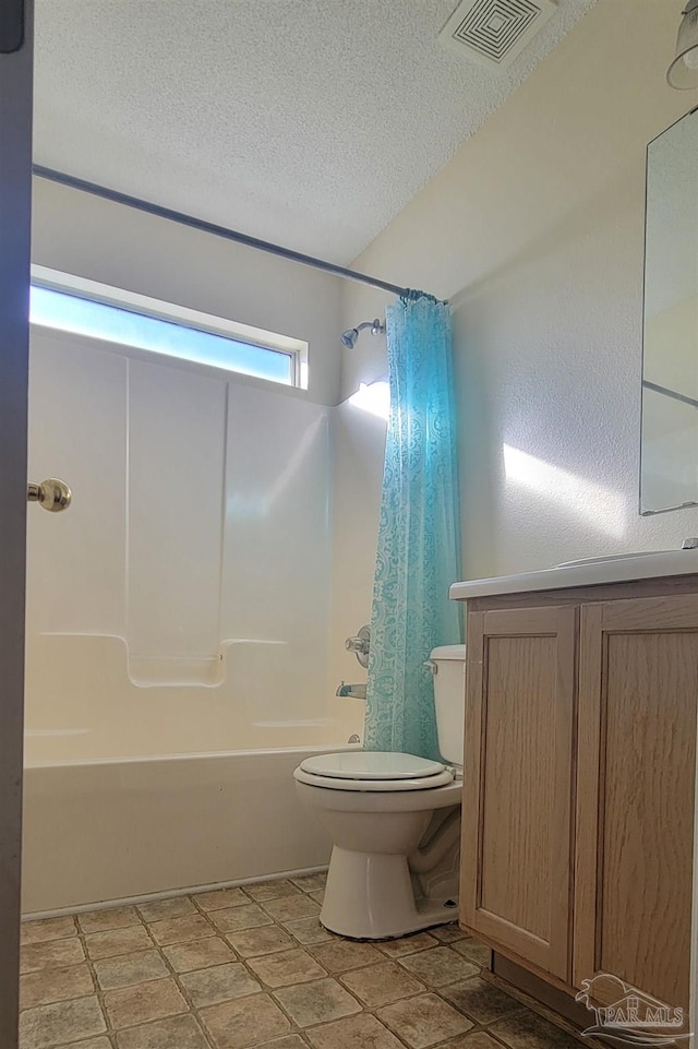 bathroom with toilet, a textured ceiling, shower / bath combo, and tile patterned flooring