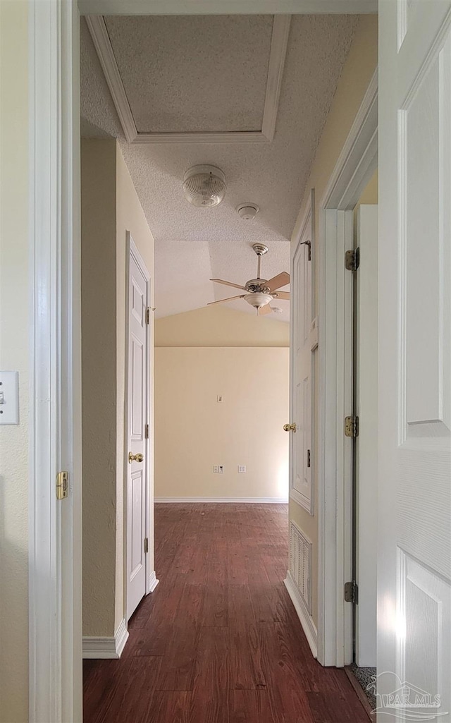 hall featuring a textured ceiling and dark wood-type flooring