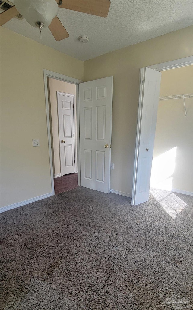 carpeted empty room with a textured ceiling and ceiling fan