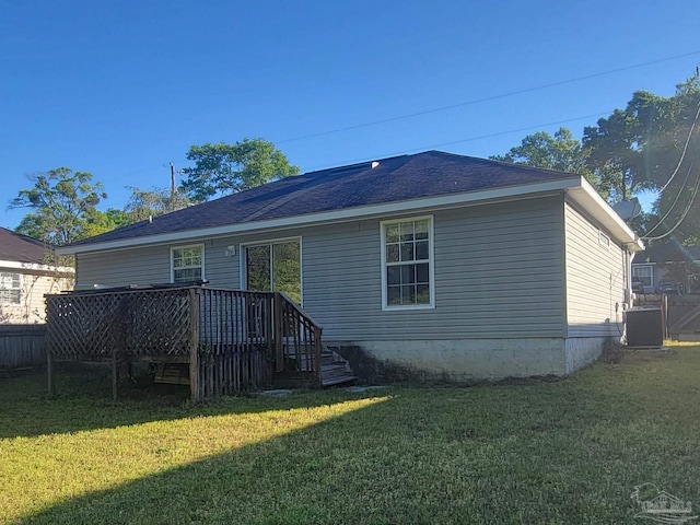 rear view of house with a deck, central AC, and a lawn