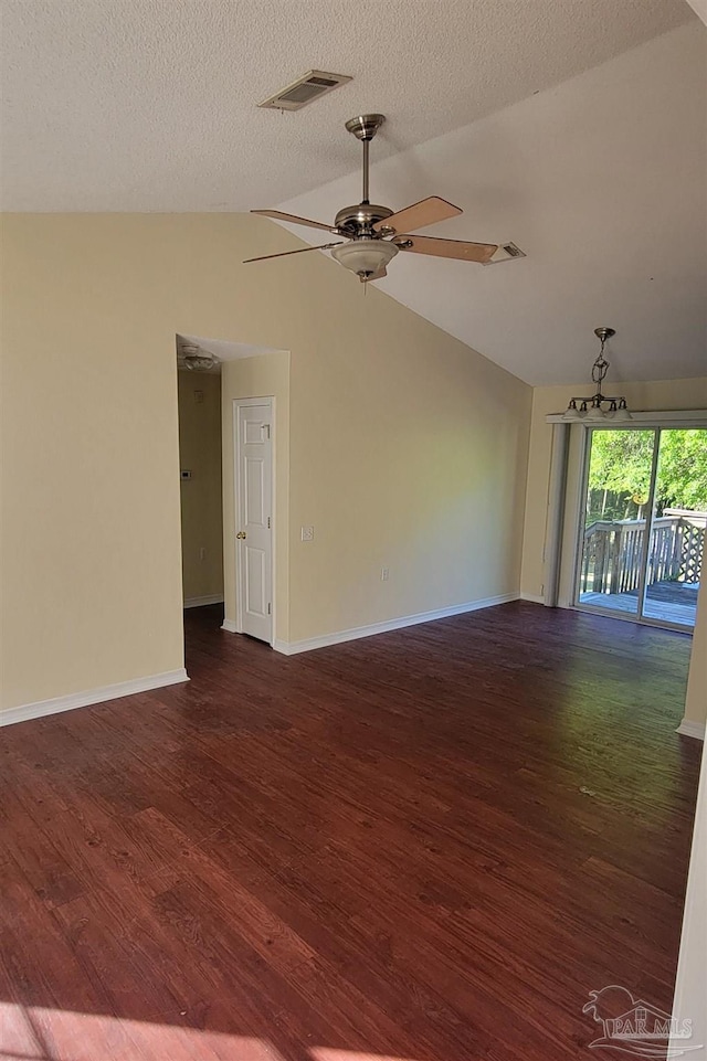 empty room featuring a textured ceiling, lofted ceiling, hardwood / wood-style flooring, and ceiling fan