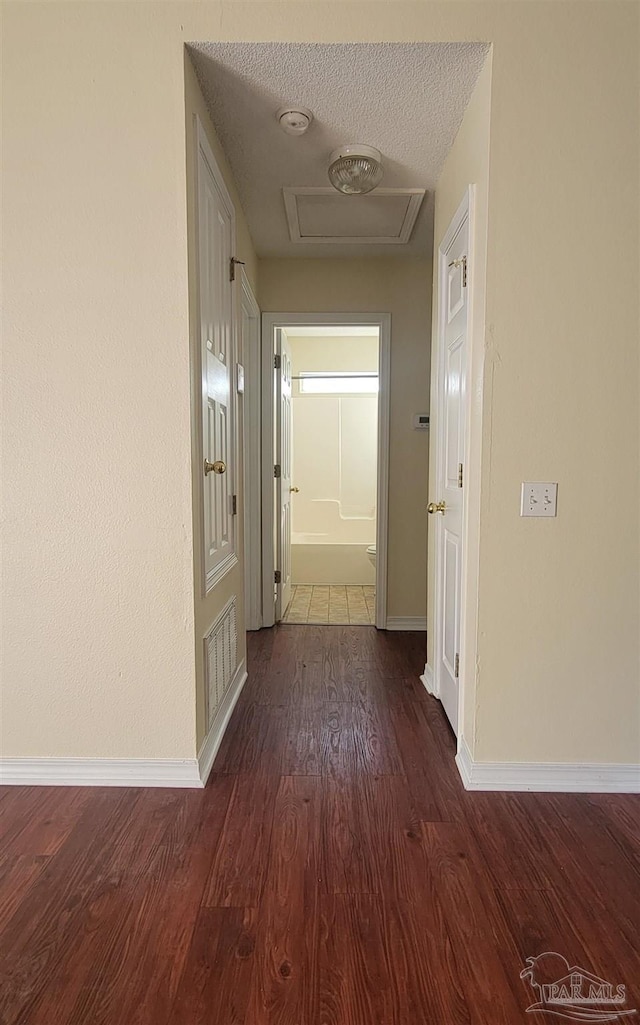 hall with hardwood / wood-style flooring and a textured ceiling