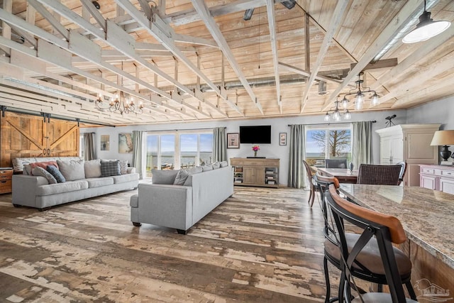 living area with wooden ceiling, a barn door, plenty of natural light, and hardwood / wood-style flooring