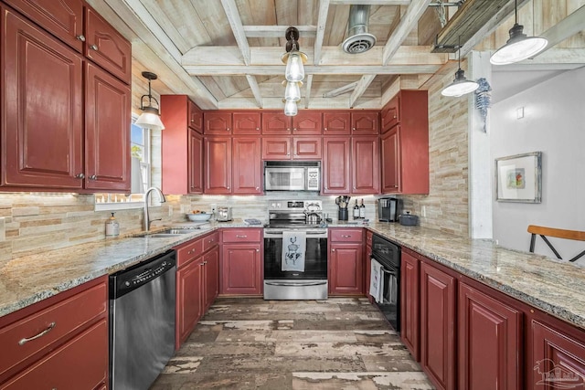 kitchen with stainless steel appliances, a sink, light stone counters, and decorative backsplash