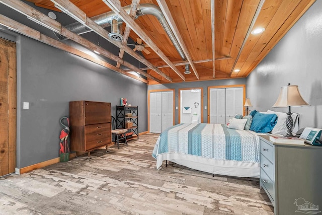 bedroom featuring multiple closets, visible vents, wood ceiling, wood finished floors, and baseboards