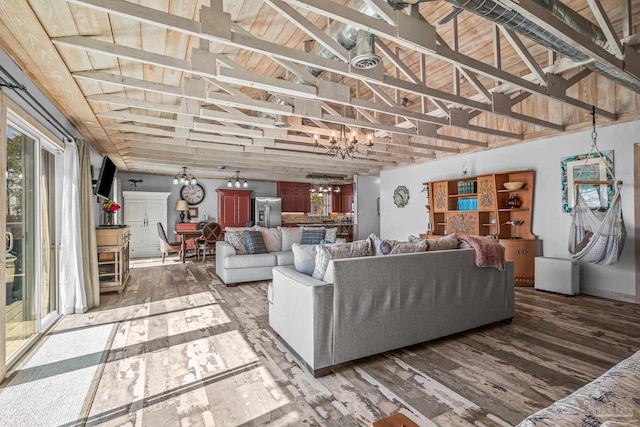 living room featuring lofted ceiling, a chandelier, and wood finished floors