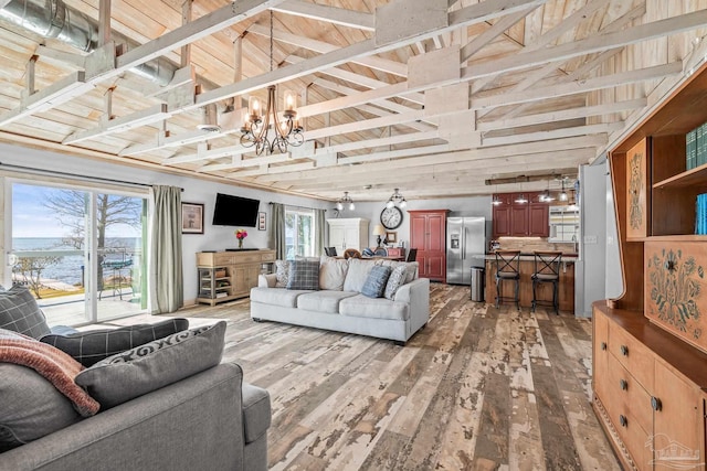 living area featuring a chandelier, light wood-type flooring, and a wealth of natural light