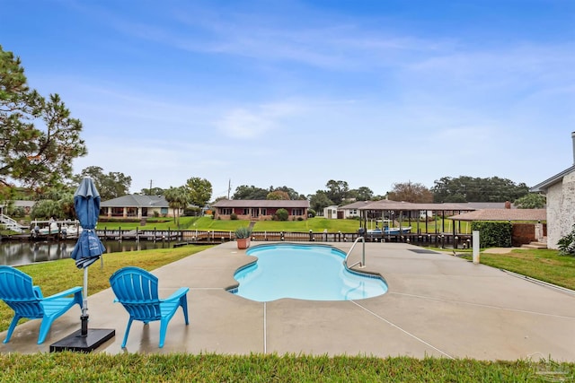 view of pool featuring a lawn, a patio area, and a water view