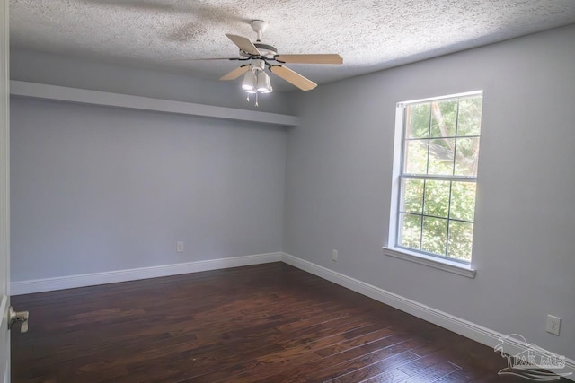 empty room with plenty of natural light, dark wood-style flooring, baseboards, and visible vents