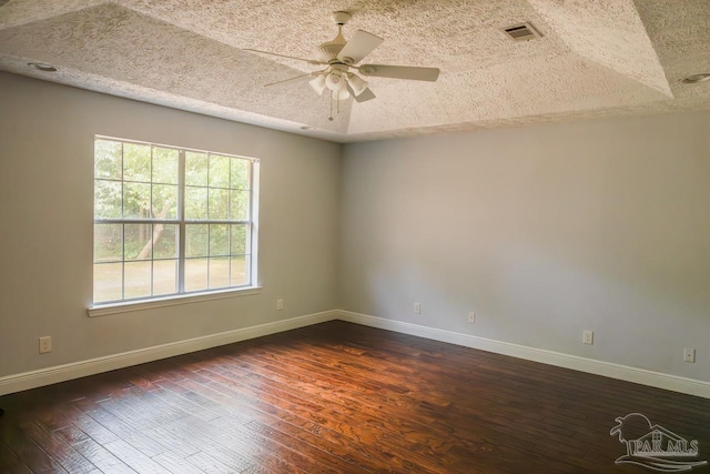 empty room with dark wood-style flooring, a textured ceiling, and a ceiling fan