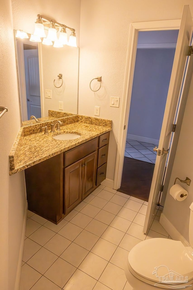 bathroom with toilet, tile patterned floors, and vanity