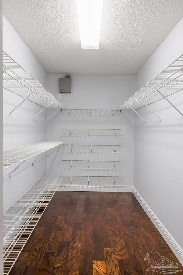 walk in closet with wood finished floors