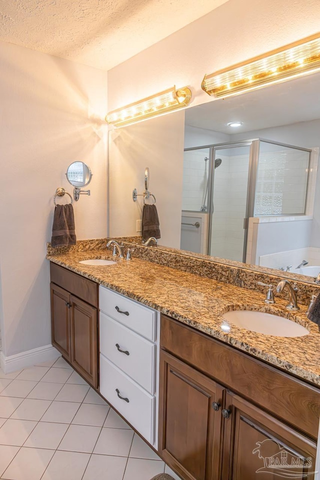 full bathroom with double vanity, a shower stall, and a sink
