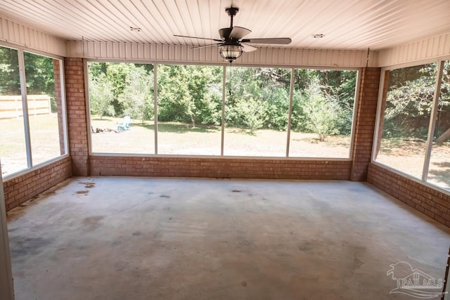 unfurnished sunroom with a ceiling fan and plenty of natural light