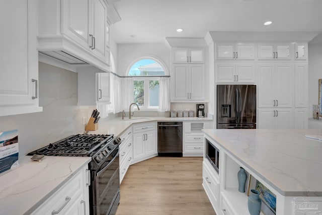 kitchen featuring black appliances, recessed lighting, white cabinetry, a sink, and glass insert cabinets