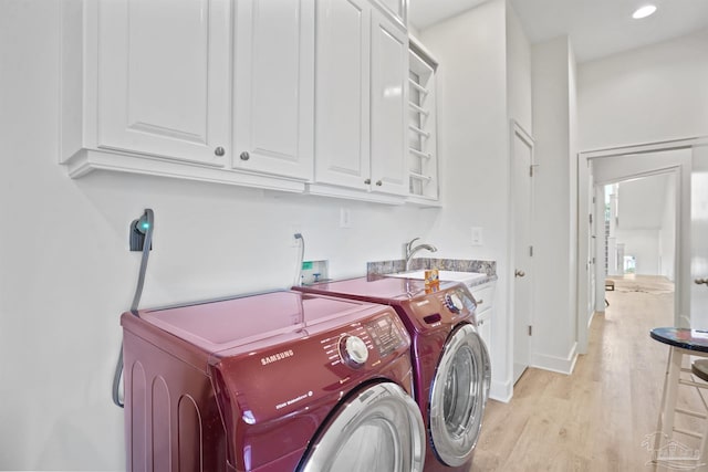 laundry room featuring washing machine and clothes dryer, cabinet space, light wood-style flooring, baseboards, and recessed lighting