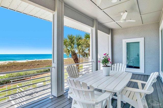 balcony featuring view of water and beach and ceiling fan