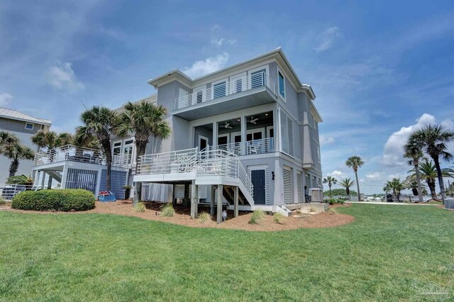 back of house with ceiling fan, a lawn, stairway, central AC, and stucco siding