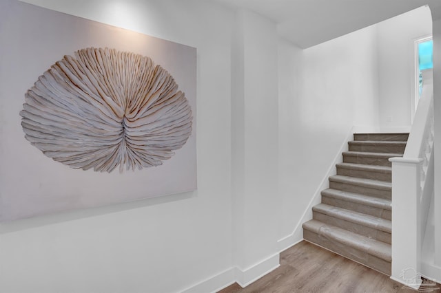 stairs with wood finished floors and baseboards