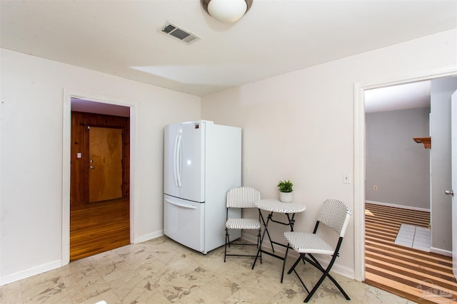 interior space featuring stacked washer and clothes dryer, marble finish floor, baseboards, and visible vents