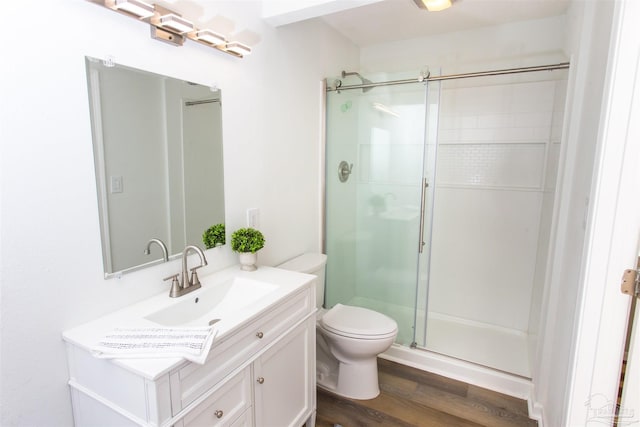 bathroom featuring a shower stall, vanity, toilet, and wood finished floors