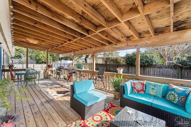 deck with outdoor dining space, a fenced backyard, and an outdoor hangout area