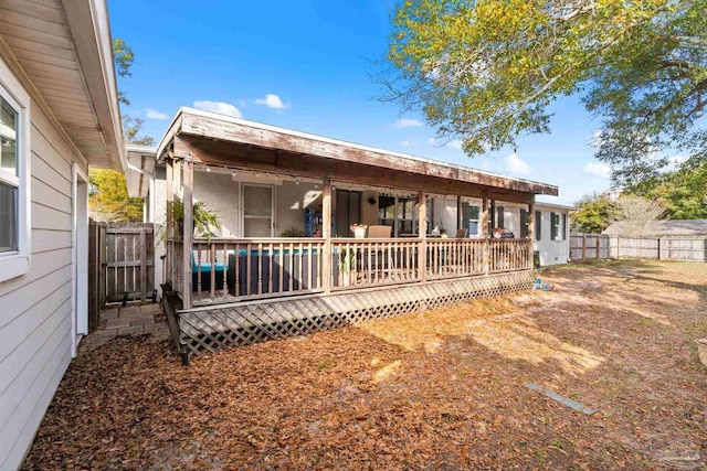 rear view of house with a wooden deck and fence