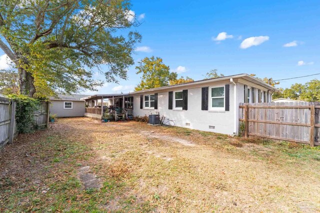rear view of property with crawl space, central AC unit, and fence private yard