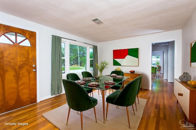 dining space with wood finished floors and visible vents