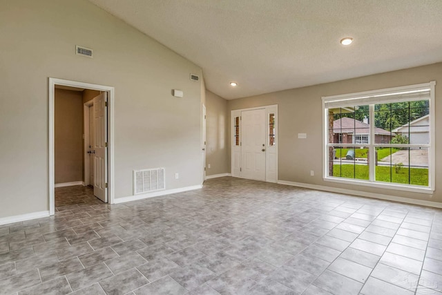 interior space with vaulted ceiling and a textured ceiling