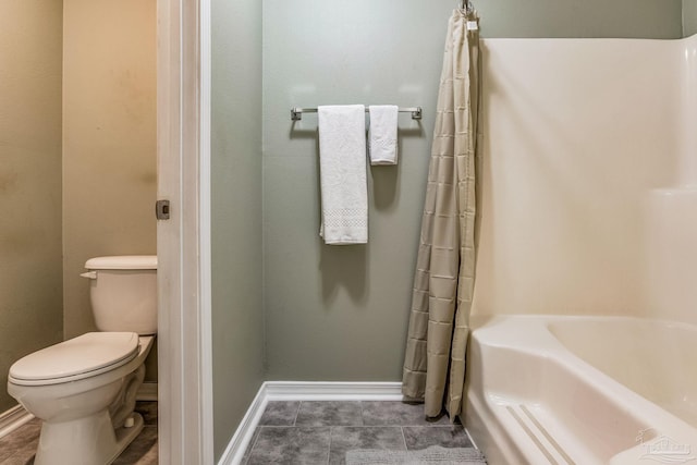 bathroom featuring toilet, tile patterned flooring, and a tub