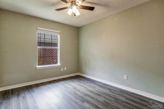 empty room with ceiling fan, dark wood-type flooring, and a textured ceiling