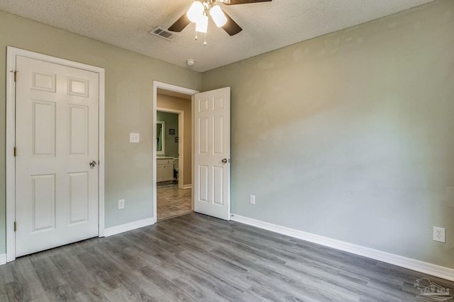 unfurnished bedroom featuring ceiling fan, light hardwood / wood-style flooring, and a textured ceiling