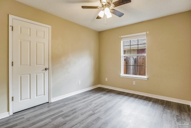 empty room featuring ceiling fan, a textured ceiling, and light hardwood / wood-style floors