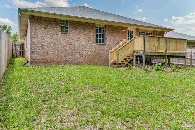 back of house with a wooden deck and a yard