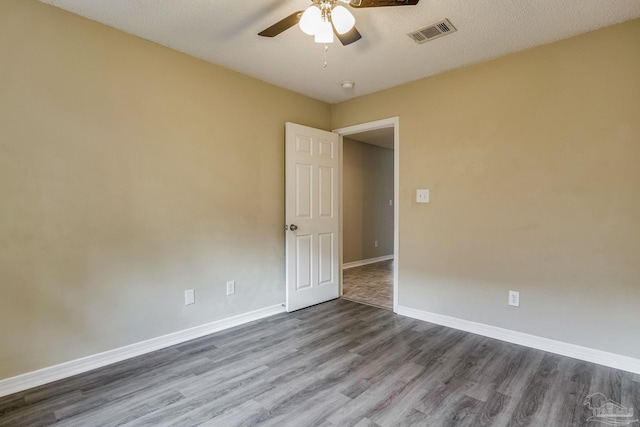 spare room featuring hardwood / wood-style flooring, a textured ceiling, and ceiling fan