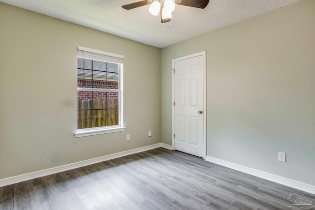 spare room with hardwood / wood-style flooring, ceiling fan, and a textured ceiling