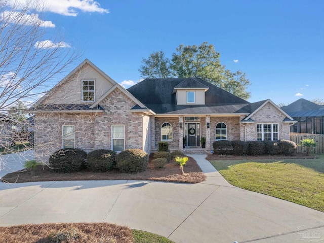 view of front facade with brick siding and a front lawn