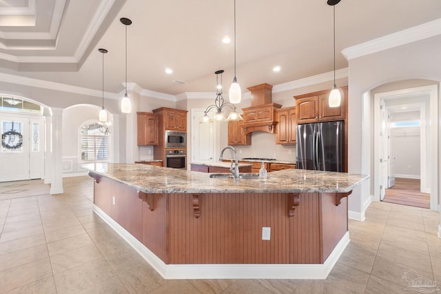 kitchen with a breakfast bar area, arched walkways, stainless steel appliances, and a sink