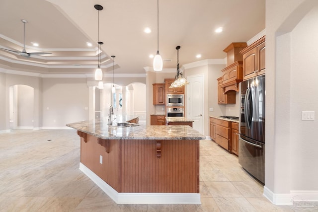 kitchen featuring arched walkways, stainless steel appliances, a spacious island, a sink, and ornamental molding