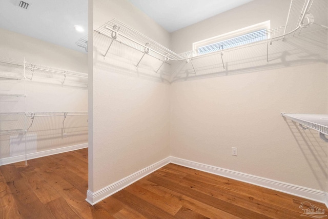 walk in closet with visible vents and wood finished floors