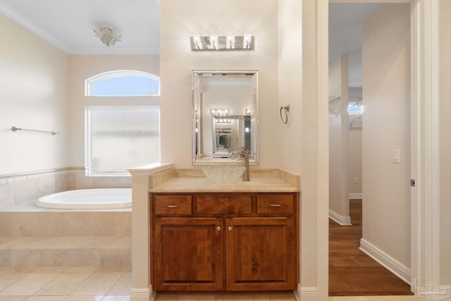 bathroom with ornamental molding, vanity, a bath, and tile patterned floors