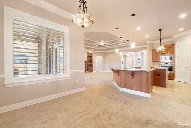 kitchen featuring appliances with stainless steel finishes, arched walkways, crown molding, and a center island with sink