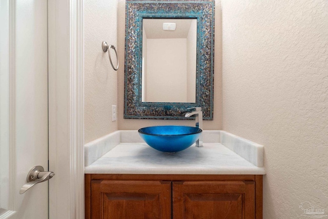 bathroom featuring a textured wall and vanity