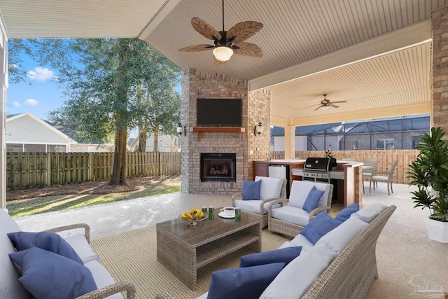 view of patio / terrace with grilling area, an outdoor living space with a fireplace, area for grilling, ceiling fan, and a fenced backyard