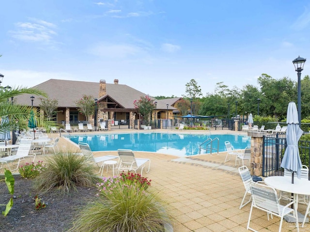 pool featuring a patio area and fence