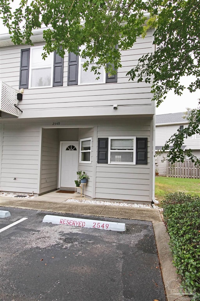 view of front of house featuring fence and uncovered parking