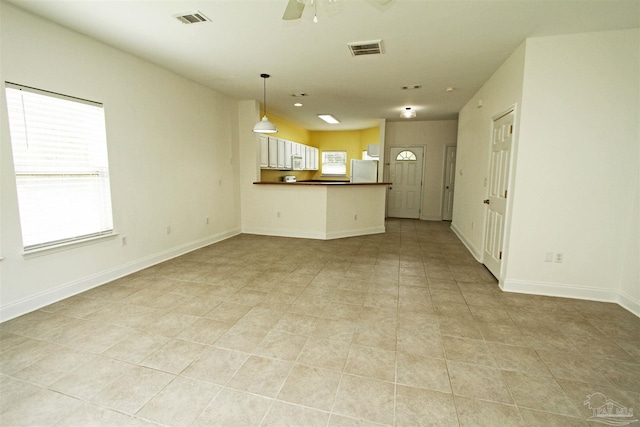 unfurnished living room featuring light tile patterned floors and ceiling fan